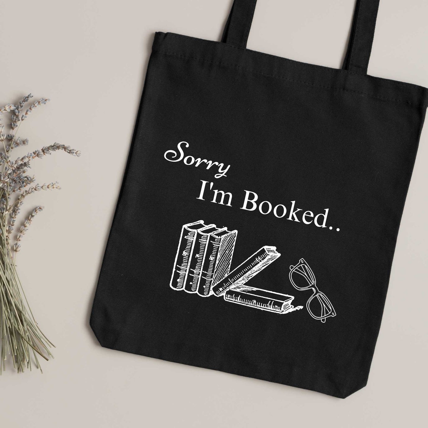 Stylish black cotton tote bag with bookish quote "Sorry I’m Booked.." – reusable library bag for bibliophiles.