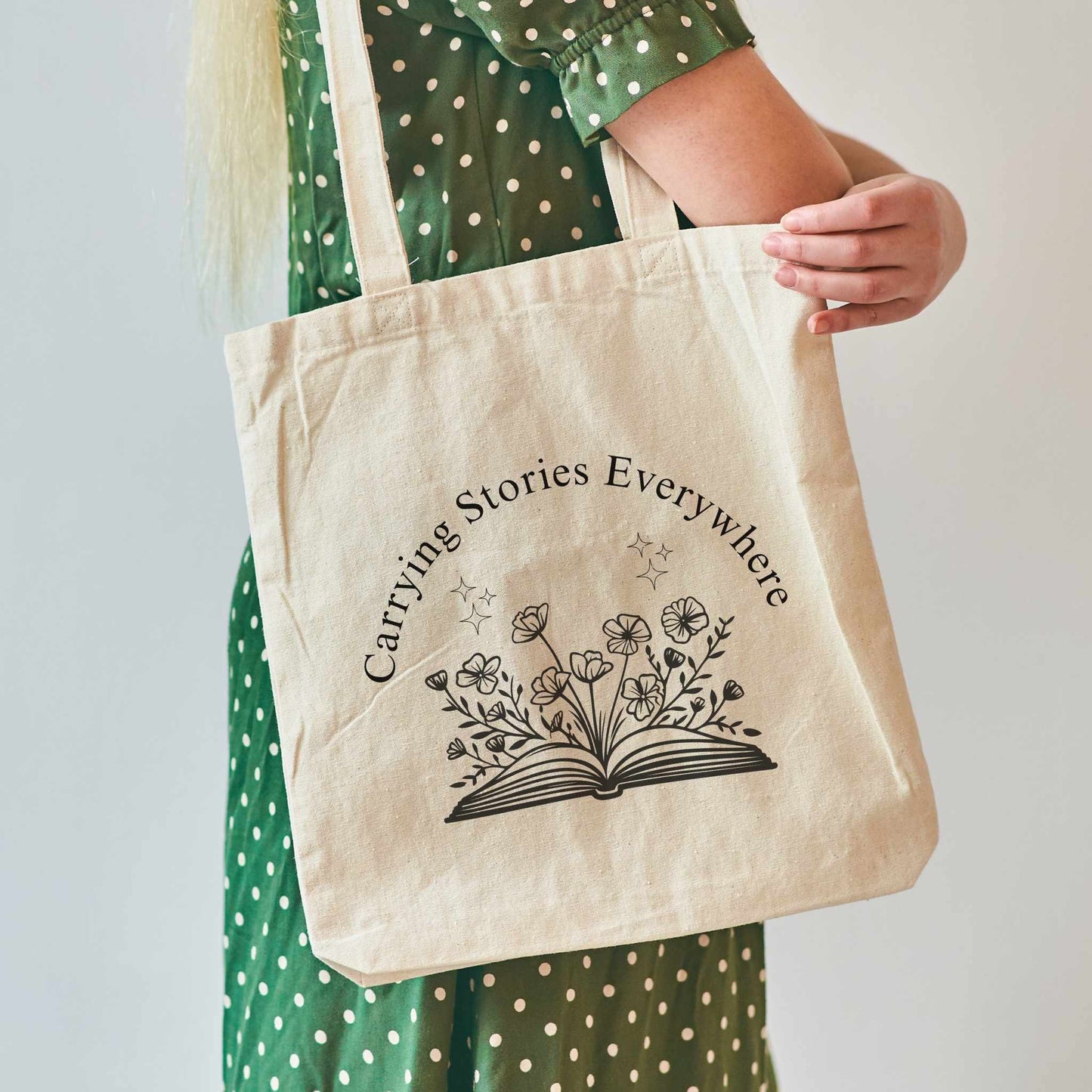 Book lover natural tote bag – 'Carrying Stories Everywhere' with floral book illustration, eco-friendly canvas bookish tote, gift for readers and librarians.